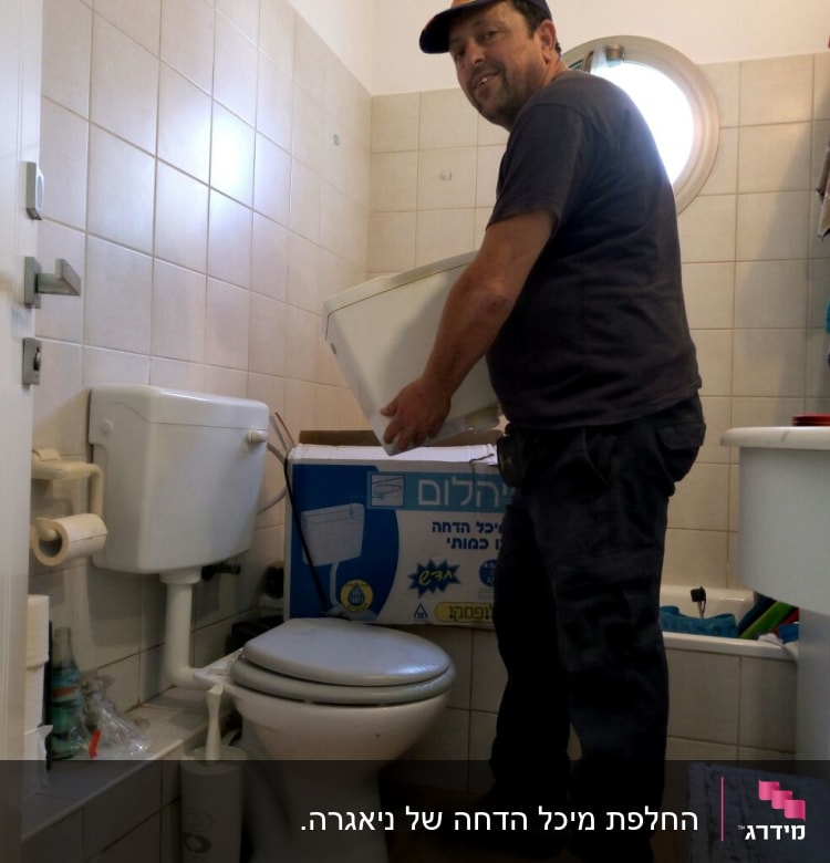 אדם מחזיק מיכל שירותים בחדר אמבטיה